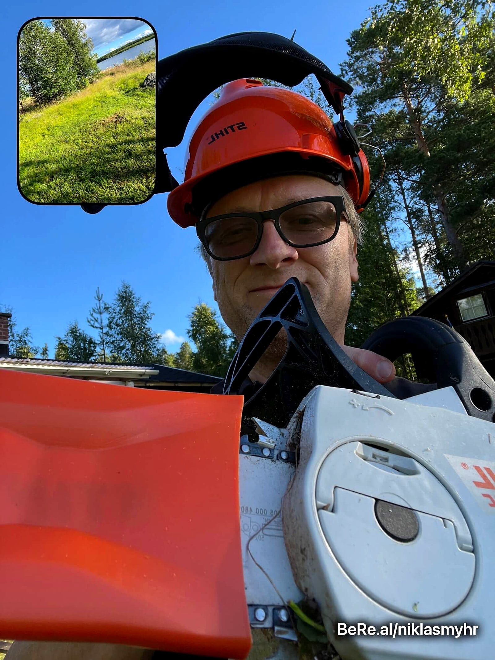 BeReal selfie in a safety helmet with a chainsaw