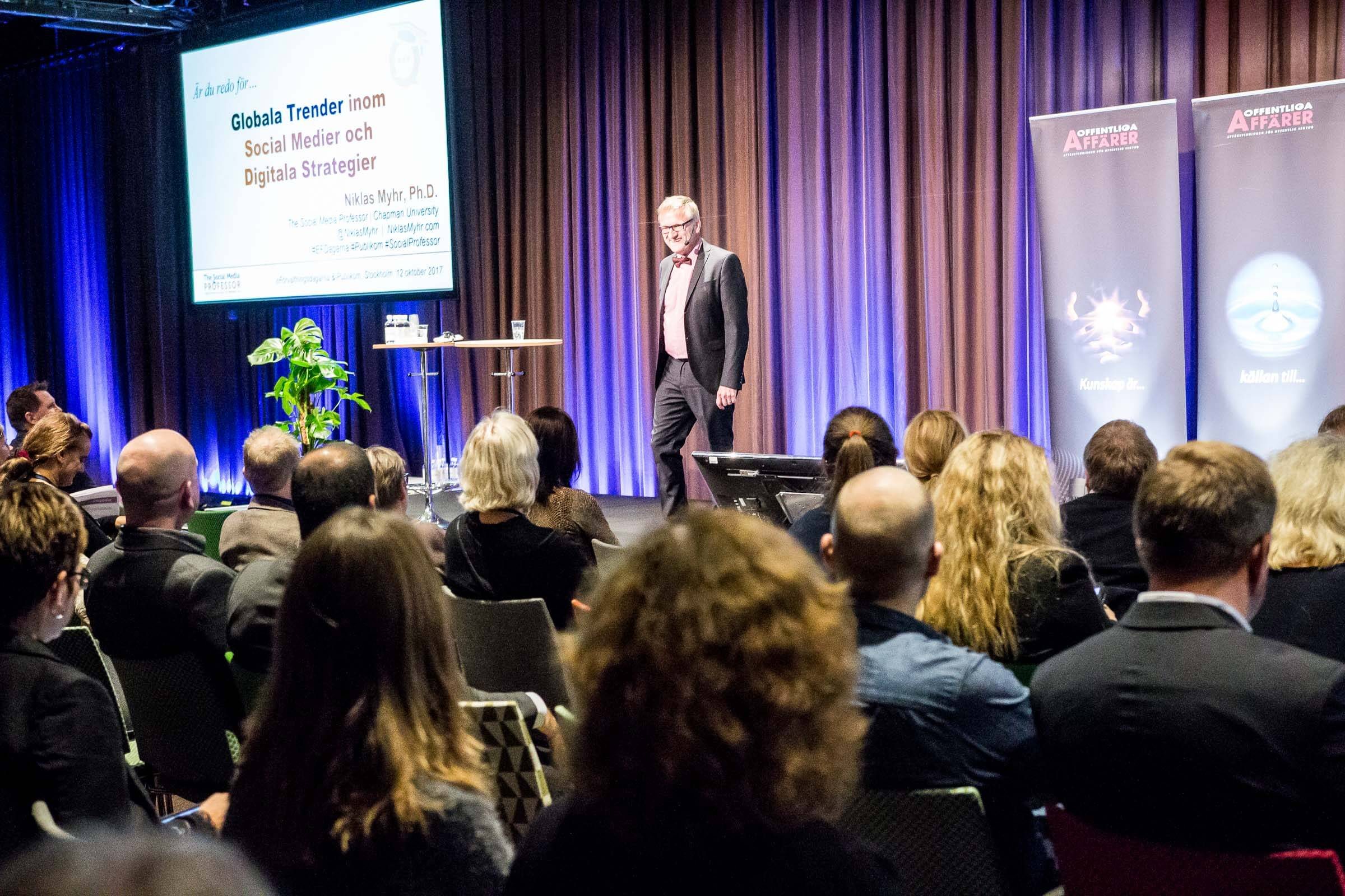 Niklas on stage in front of a full hall of public sector executives in Stockholm