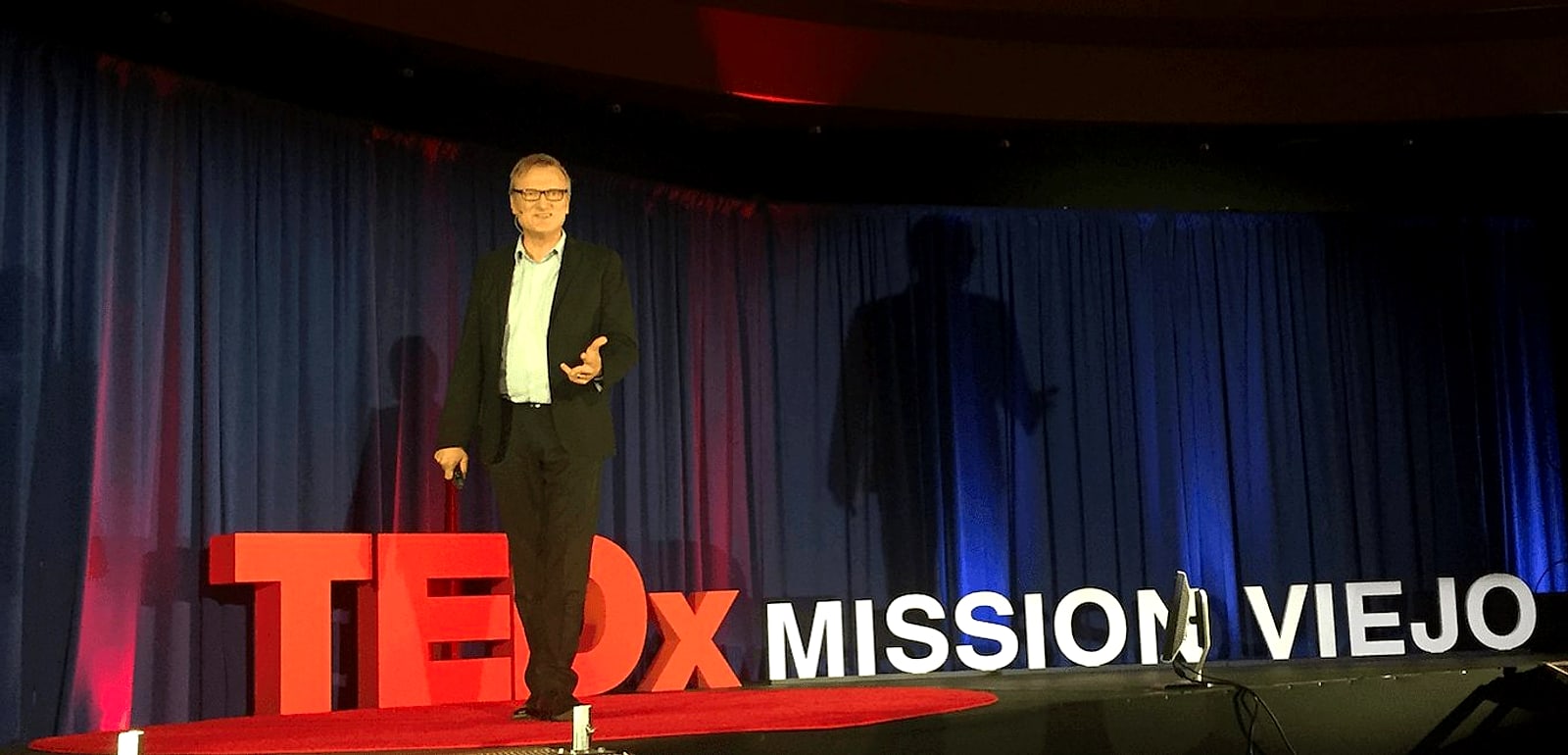 Niklas on the TEDxMissionViejo stage beside the red TEDx letters